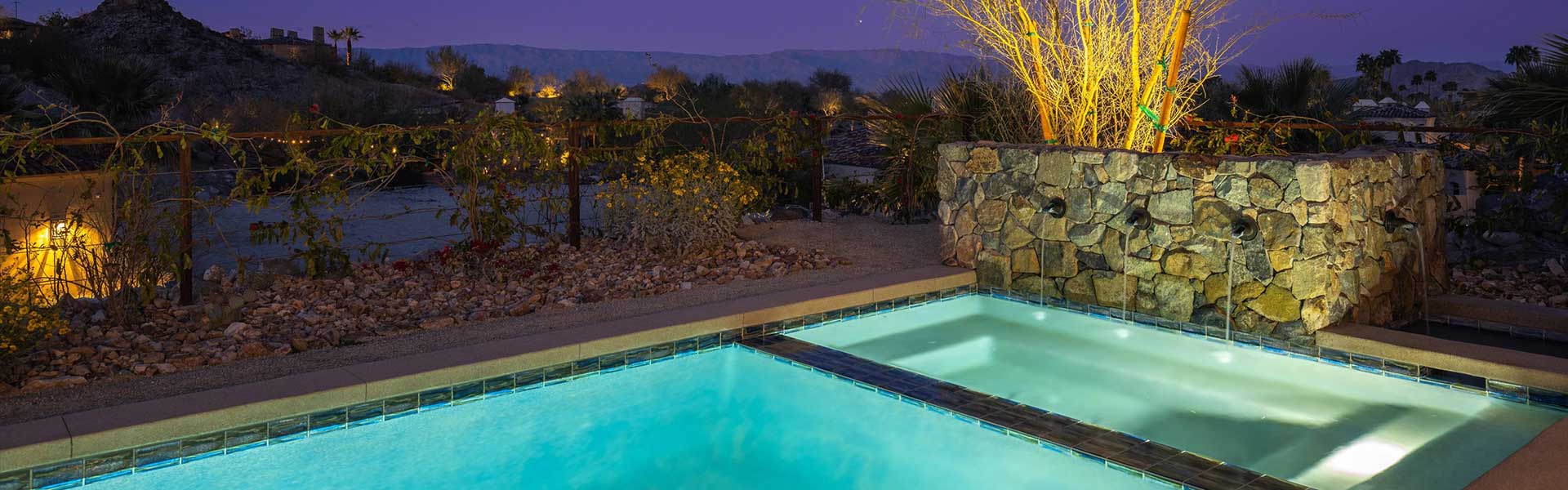 Evening pool lit with mountains on horizon.